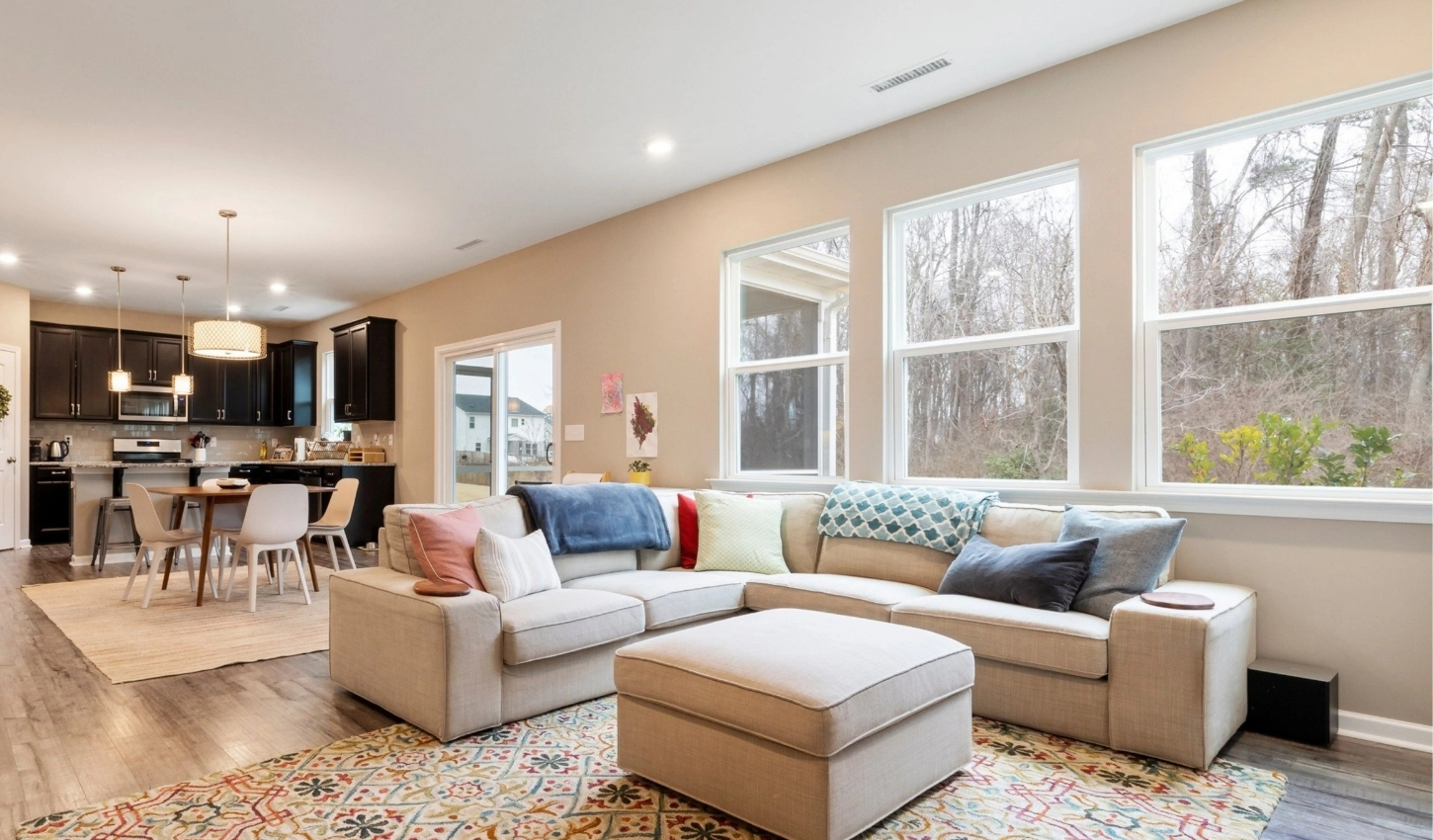 Modern living room with large windows showcasing natural light, ideal for smart window film installation in homes for privacy and energy efficiency.